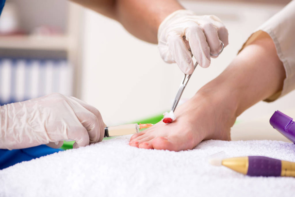 Podologe behandelt Füße während des Eingriffs - Foto, Bild