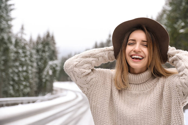 Young woman in warm sweater outdoors. Winter vacation - 写真・画像