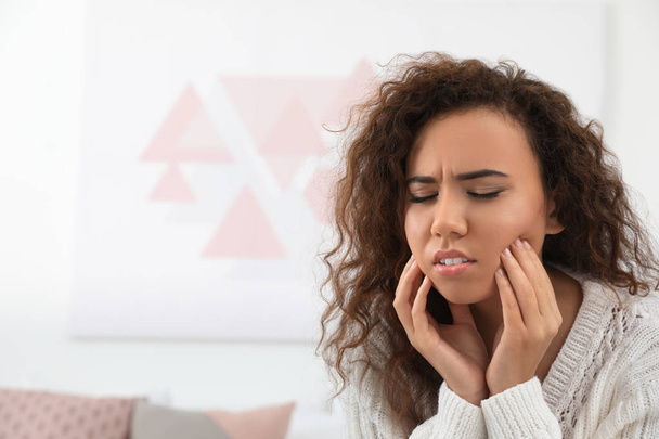 Афро-американських жінка, яка страждає від болить зуб в приміщенні. Місце для тексту - Фото, зображення