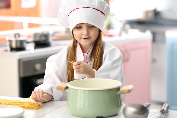 Menina bonito vestido como chef jogar em casa
 - Foto, Imagem