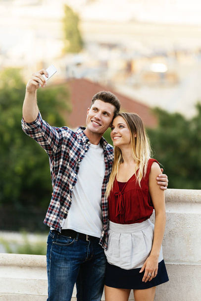 Romantic Young Couple taking a photo with mobile phone. Relationship concept. - Photo, Image