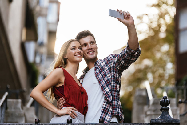 Romantic Young Couple taking a photo with mobile phone. Relationship concept. - Photo, Image