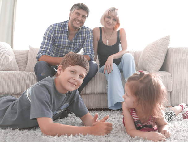 Portrait of happy family sitting together in living room - Foto, afbeelding