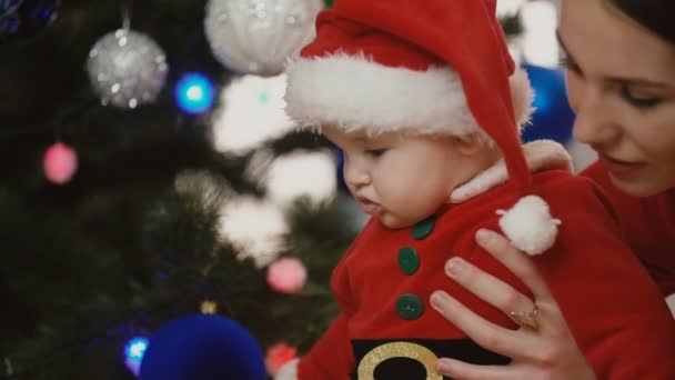 little girl dressed as Santa with mom - Кадри, відео