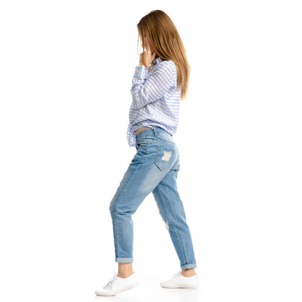 Woman in blue jeans and shirt goes - Φωτογραφία, εικόνα