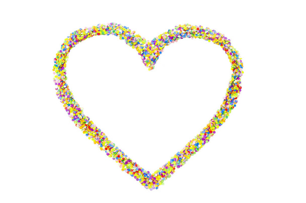 Heart made of colored confetti. Small circles of colored paper. White background. View from above. Colored heart. - 写真・画像