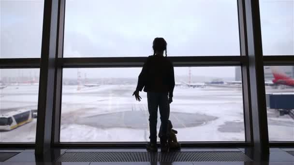 Девочка в аэропорту у большого окна в ожидании посадки
 - Кадры, видео