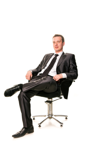 Confident smiling young businessman sitting on a chair - Fotó, kép