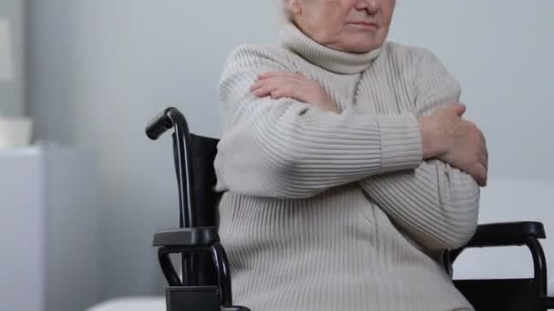 Jeune infirmière utile couvrant dame handicapée en fauteuil roulant avec plaid chaud, soins
 - Séquence, vidéo