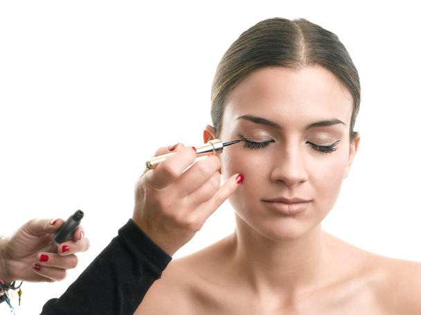 Makeup artist applying eyeliner on eyelid - Fotó, kép