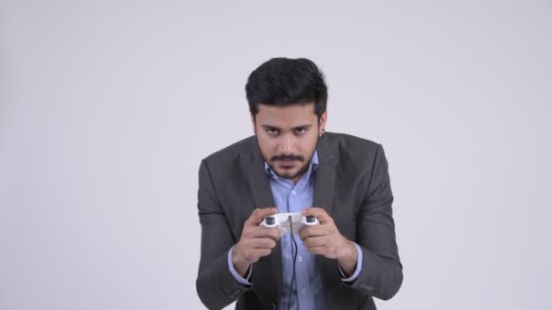 Young happy bearded Indian businessman playing games and winning - Materiał filmowy, wideo