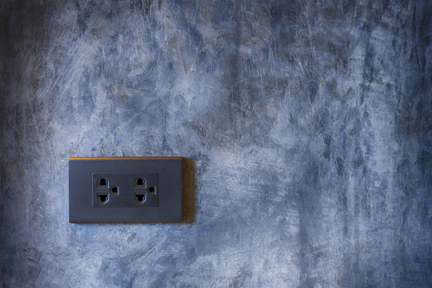 Zwarte stopcontact met cementwand achtergrond - Foto, afbeelding