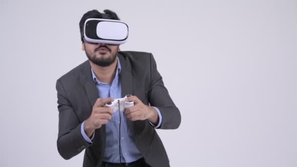 Young bearded Indian businessman playing games and using virtual reality headset - Filmagem, Vídeo