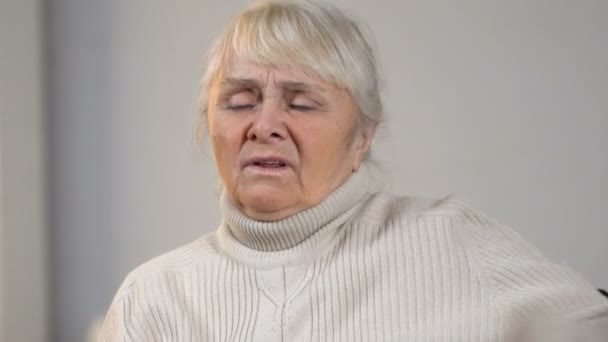 Senior disabled lady suffering pain in heart and looking at medication on table - Záběry, video