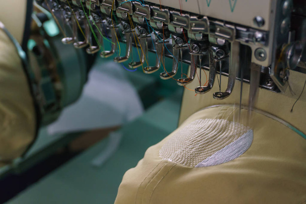Aguja de la máquina del bordado en la industria textil en los fabricantes de prendas de vestir, Tapa del bordado en curso, Aguja con rosca (enfoque selectivo y enfoque suave
) - Foto, imagen