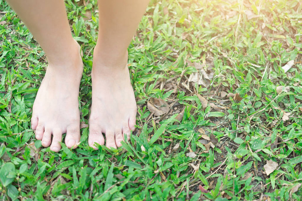 Bare feet standing on the lawn for relaxation.  Therapy of nature concept - Zdjęcie, obraz