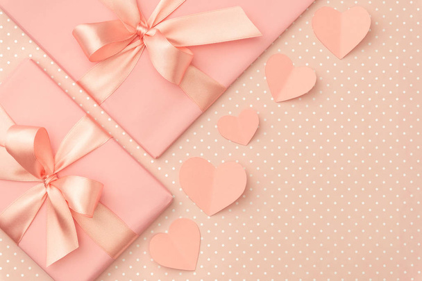 Decoración día de San Valentín en la mesa vista superior. Composición plana de forma de corazón y caja de regalo rosa con cinta sobre fondo de coral vivo. Concepto del día de las madres. 8 Marzo Día de la mujer
 - Foto, Imagen