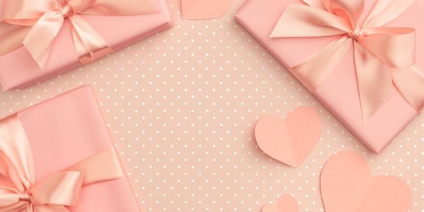 Valentine day idea composition: pink or coral present box with ribbon and small hearts on living coral background. Top view. Flat lay - Foto, Imagen