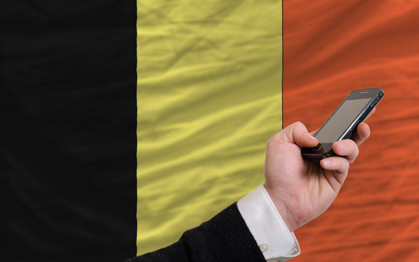 matkapuhelin Belgian kansallisen lipun edessä
 - Valokuva, kuva