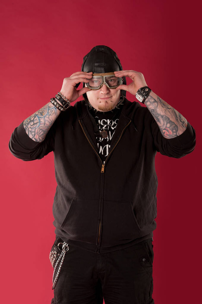 Portrait of a cool, chubby rocker on red background - Photo, Image