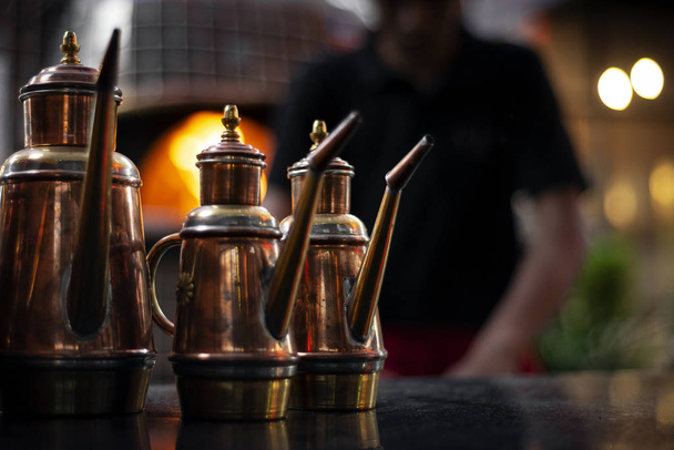 classic olive oil copper cruet traditional dispenser detail in italian restaurant - Foto, afbeelding