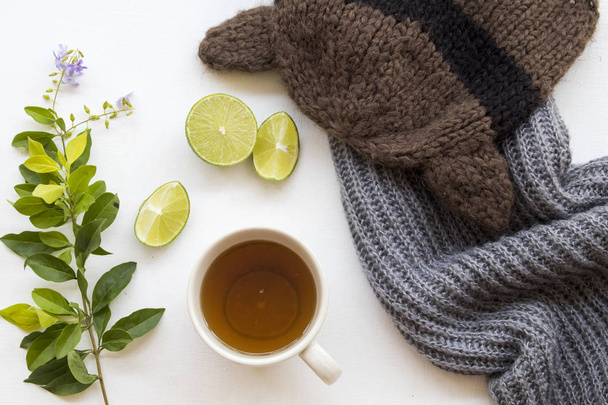 herbal honey lemon tea healthy drinks health care for sore throat with lemon slice and knitting wool scarf ,hat in winter season with purple flowers decoration on background white wooden - 写真・画像