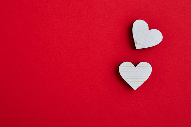 Paar zweier verliebter Holzherzen auf rotem Hintergrund. Leerer Kopierraum. fröhlicher Valentinstag - 14. Februar - Foto, Bild