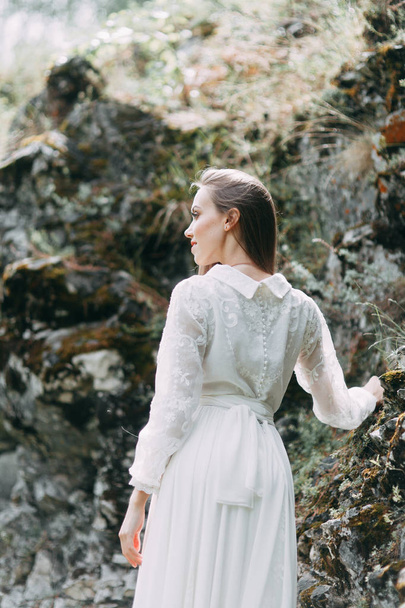 Morning bride on a beautiful panoramic location. Girl in boudoir dress and cliffs. - Foto, Imagem