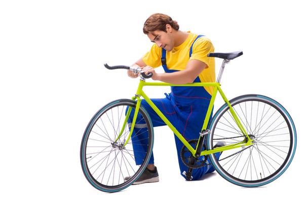 Ο άνθρωπος επισκευάζει το ποδήλατό του απομονωμένο σε λευκό φόντο - Φωτογραφία, εικόνα
