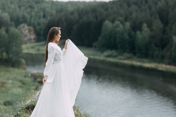 Morning bride on a beautiful panoramic location. Girl in boudoir dress and cliffs. - Foto, Imagem
