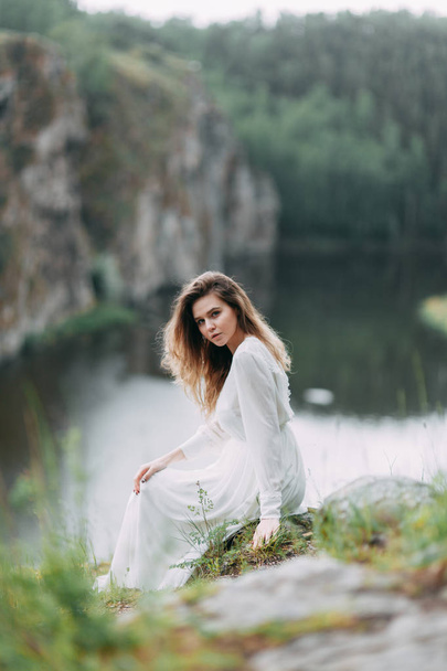 Boudoir morning bride in nature in a white dress. Wedding series on cliffs and river bends. - Foto, Imagem