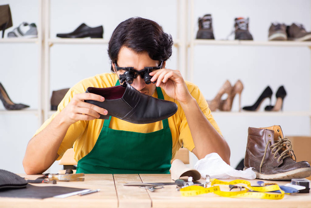 Jongeman herstellen van schoenen in werkplaats  - Foto, afbeelding