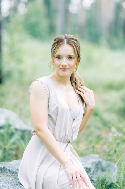 Boudoir photo shoot of the bride in the woods with a bouquet. Flying dress and beautiful girl in the Park. - Foto, Bild