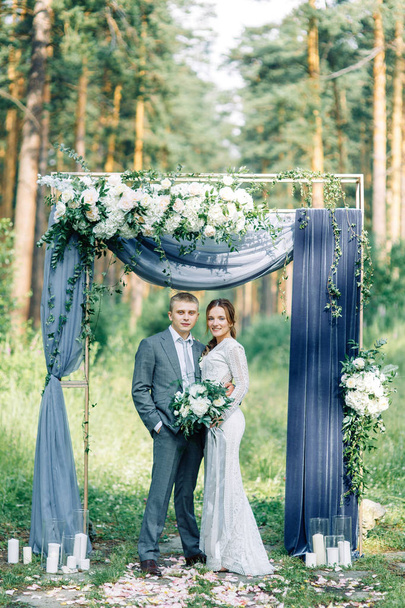Wedding ceremony at the arch with pine forest in the style of fine art. Beautiful couple and traditions at a wedding in Europe. - Photo, image