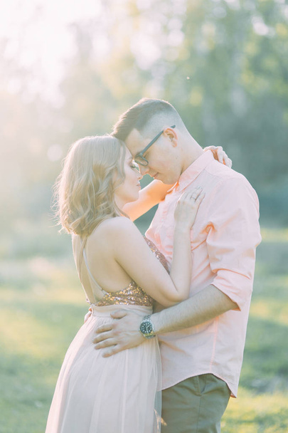 Beautiful couple in the forest at sunset in the style of fine art. Photo shoot in nature with the sun. - Foto, immagini