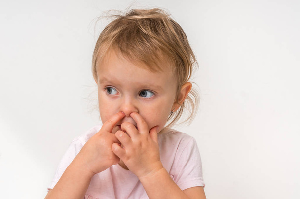 Bébé fille se picore le nez avec le doigt à l'intérieur concept d'hygiène
 - Photo, image