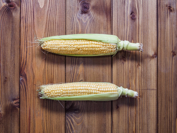 Két nyers kukorica a cob fából készült háttér  - Fotó, kép
