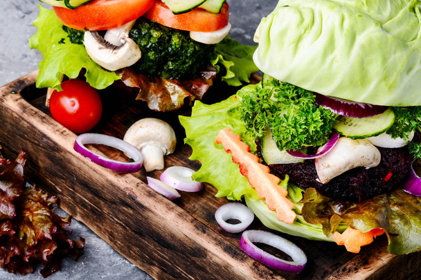 野菜のハンバーガーは、素朴なテーブルにまな板の上提供しています。ビーガン フード - 写真・画像