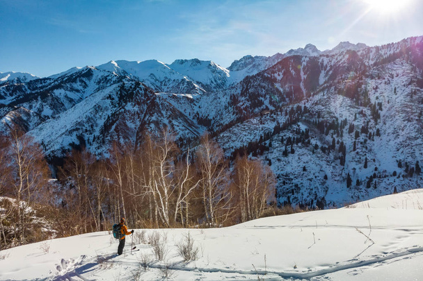 Un joven viaja en las montañas nevadas en invierno en esquís. Tour de esquí
. - Foto, Imagen