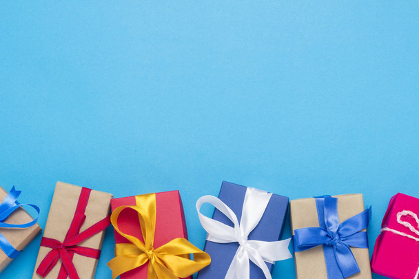 Un montón de cajas de regalo sobre un fondo azul. Concepto de vacaciones, Año Nuevo, Navidad, Cumpleaños, San Valentín. Copiar espacio. Piso tendido, vista superior
 - Foto, imagen
