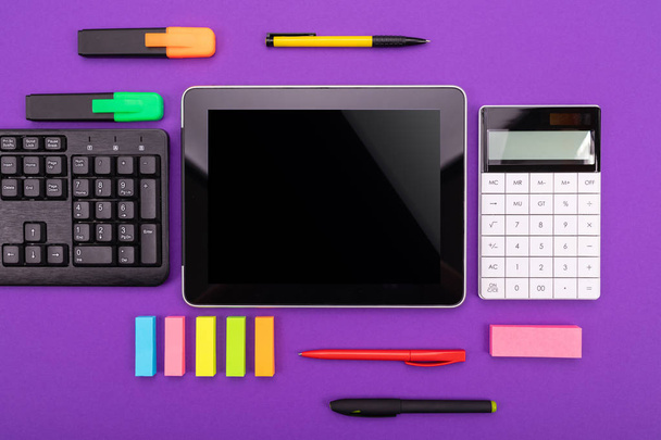 Современное рабочее пространство с планшетом, клавиатурой и калькулятором на фиолетовом фоне. Концепция плоского слоя
 - Фото, изображение
