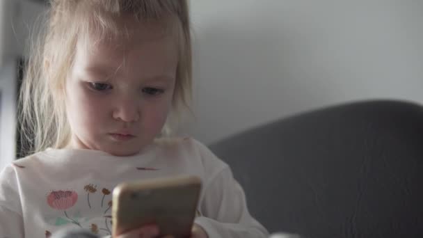 Cute little girl playing mobile phone - Materiał filmowy, wideo
