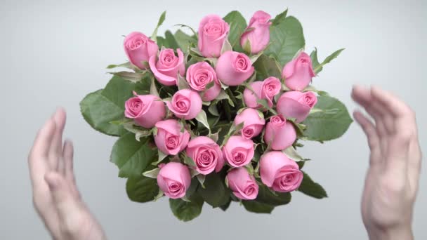 Női kezek érintse meg egy csokor rózsaszín rózsa az asztalon. Lassú mozgás. 12 - Felvétel, videó