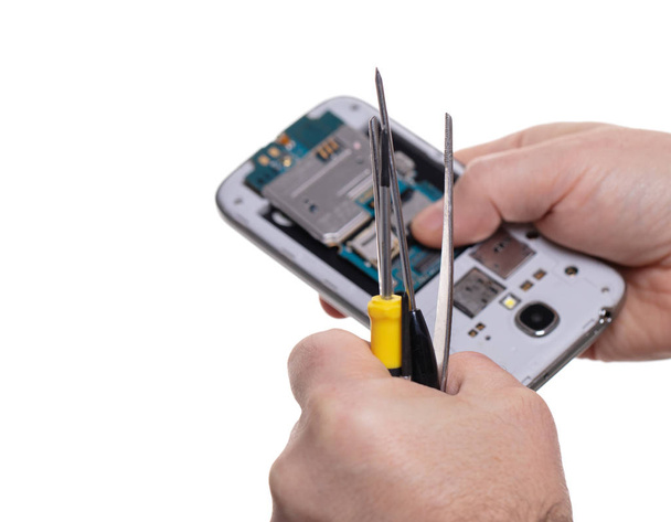 reparação do telefone móvel, mãos close-up em um fundo isolado branco
 - Foto, Imagem