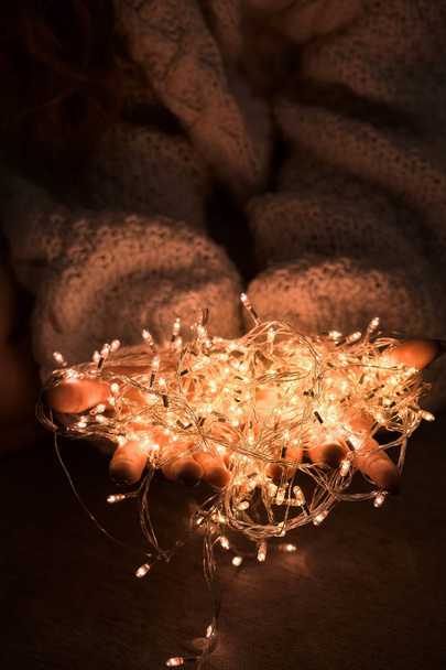 Female hands hold the garland, close-up - Foto, afbeelding