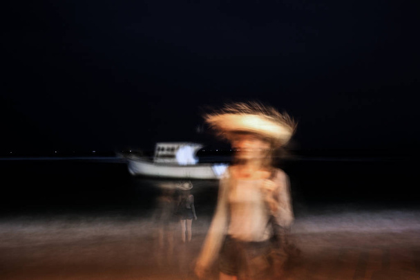 長時間露光の夜の海での女の子。デフォーカス - 写真・画像