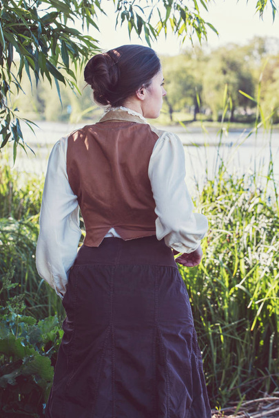 Woman in vintage clothes on the river bank - Photo, Image