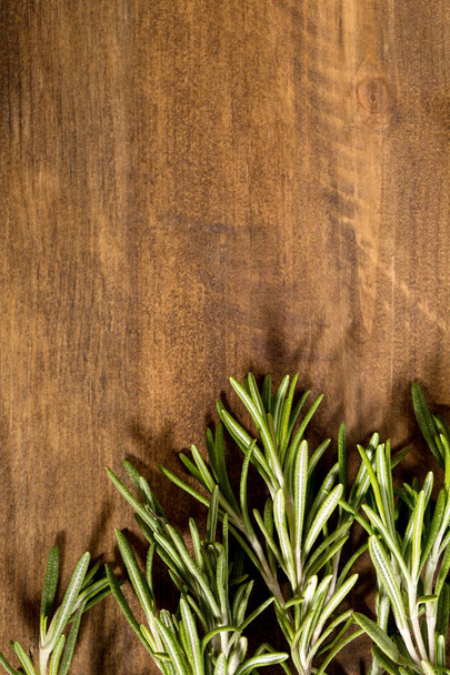 A bunch of fresh rosemary on a wooden board - Foto, afbeelding