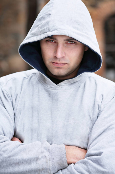 Een knappe jonge man in een grijze kap - Foto, afbeelding