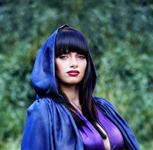 witch in a blue cloak in the forest - Photo, Image